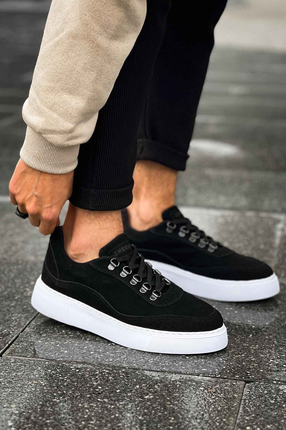 Men's black suede lace-up sneakers with white rubber sole, side view