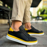 Men's black sneakers with yellow toe detail and white sole, front side view