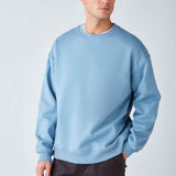 Men's oversized light blue sweatshirt, side view with crew neck and dropped shoulders