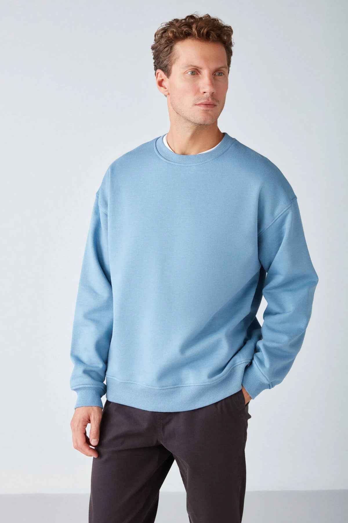 Men's oversized light blue sweatshirt, side view with crew neck and dropped shoulders