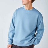 Men's oversized light blue sweatshirt, three-quarter view showing crew neck and hem