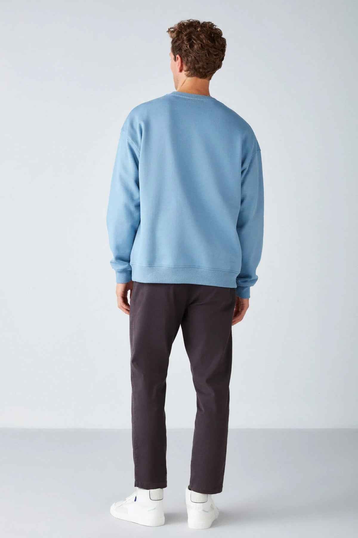Men's oversized light blue sweatshirt, back view with crew neck and ribbed cuffs