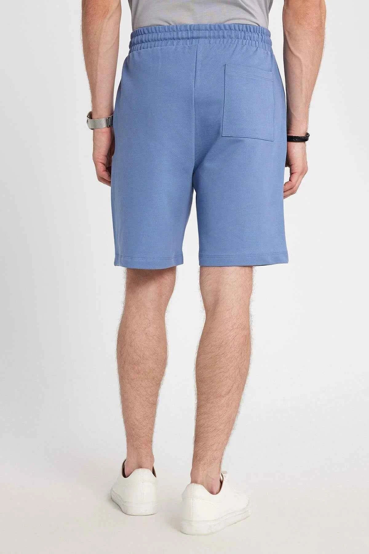 Men's blue shorts with front pockets and stitched leg seams, knee-length
