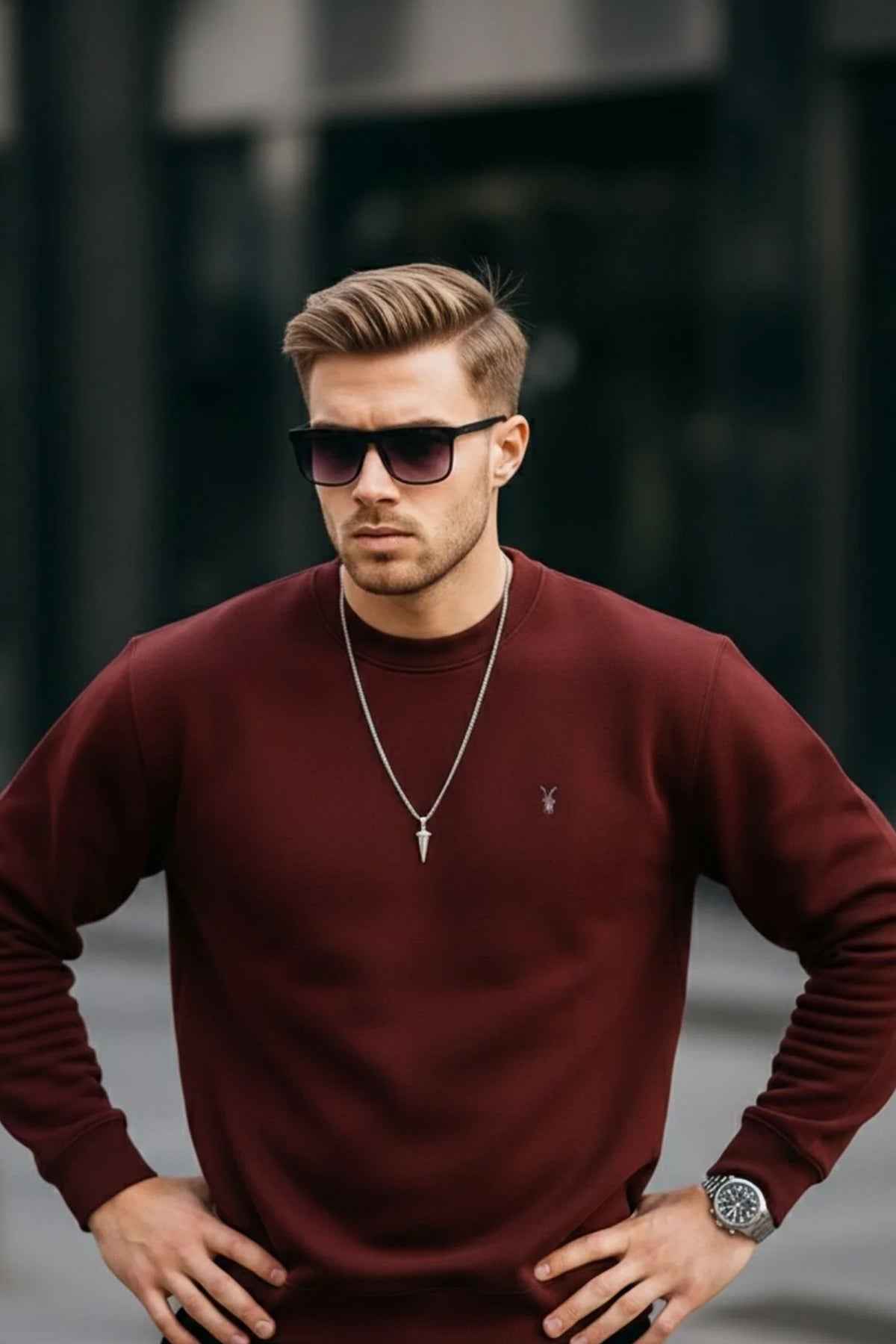 Men's maroon crewneck sweatshirt with small chest logo, hands on waist, long sleeves