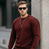 Men's maroon crewneck sweatshirt with small chest logo, long sleeves, relaxed stance