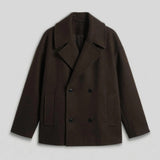 Dark brown oversized double-breasted coat with notch lapels and flap pockets.
