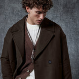 Dark brown double-breasted coat with button front, notch lapels, and flap pockets.