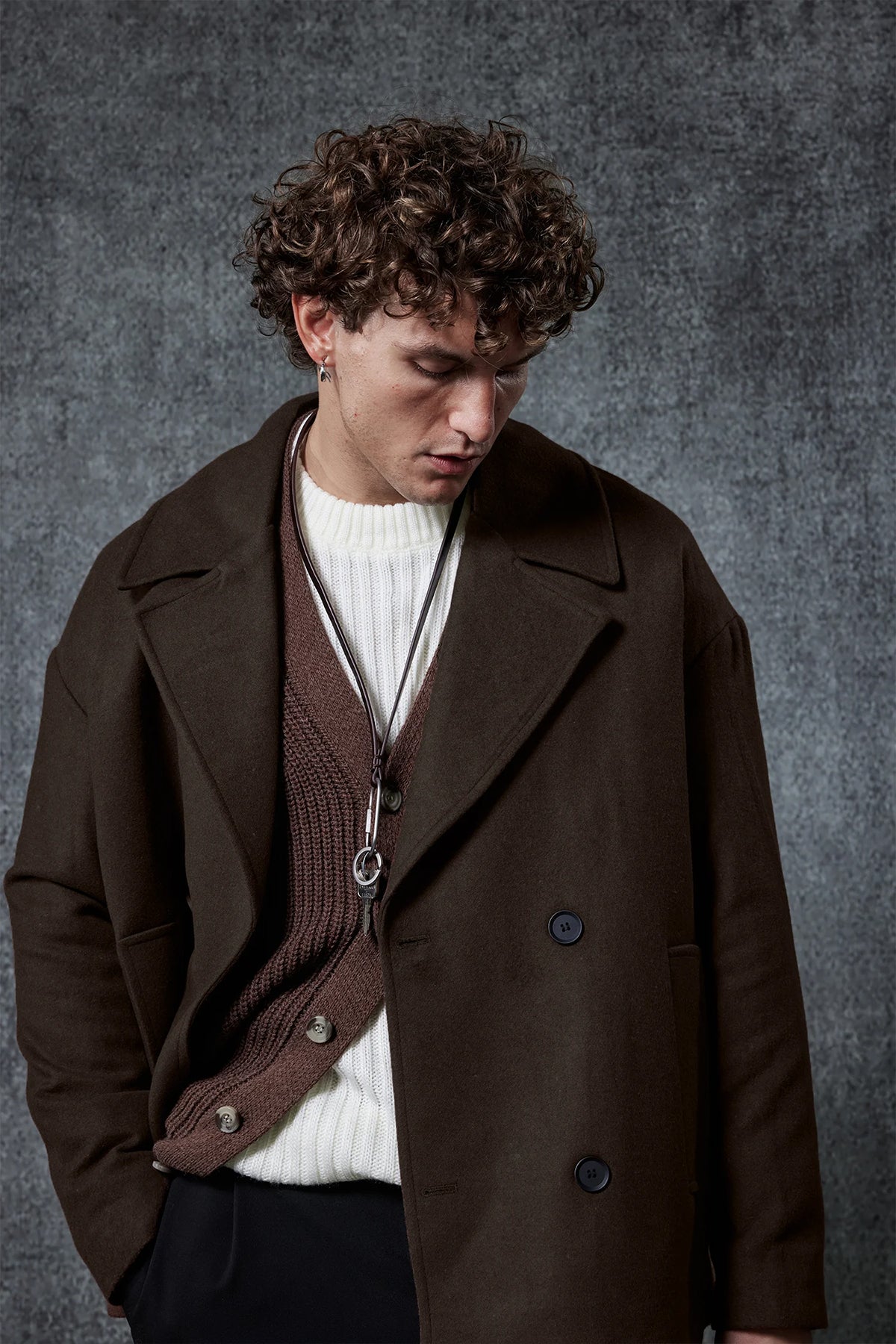 Dark brown double-breasted coat with button front, notch lapels, and flap pockets.