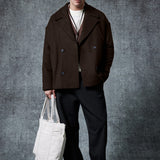Dark brown double-breasted coat with notch lapels, buttoned front, and flap pockets.