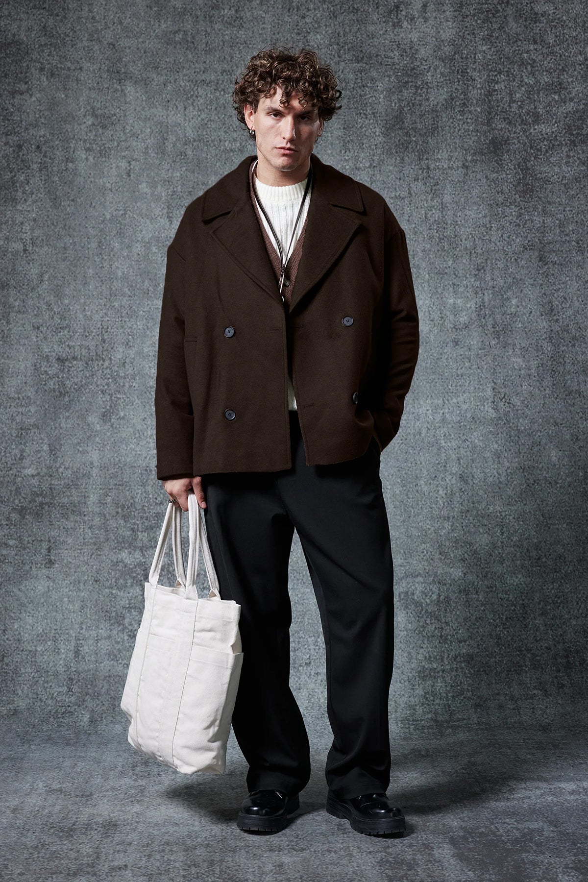 Dark brown double-breasted coat with notch lapels, buttoned front, and flap pockets.