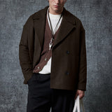 Dark brown double-breasted coat with flap pockets, buttoned front, and long sleeves.