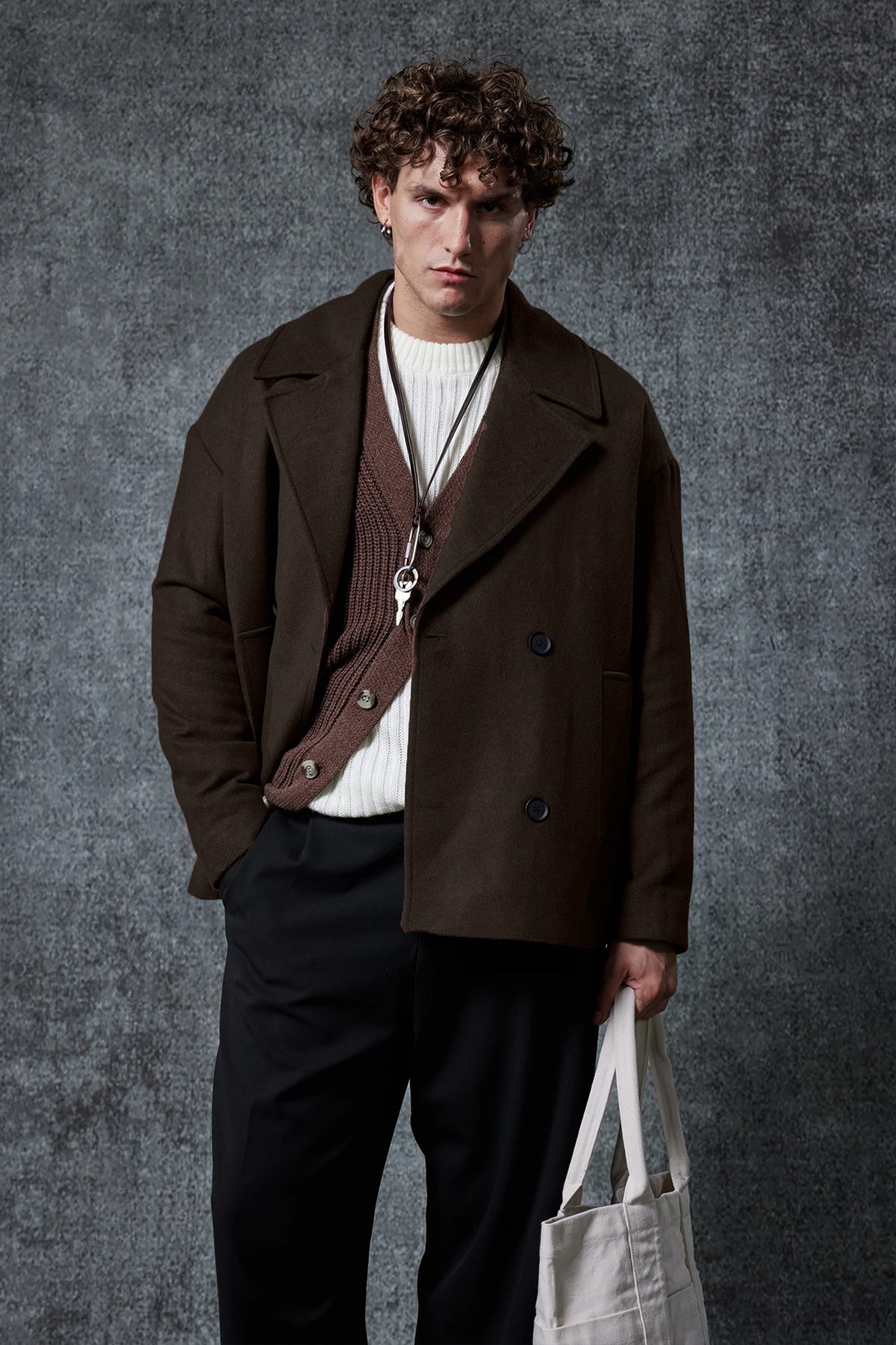 Dark brown double-breasted coat with flap pockets, buttoned front, and long sleeves.
