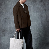 Dark brown double-breasted coat with structured shoulders and flap pockets.