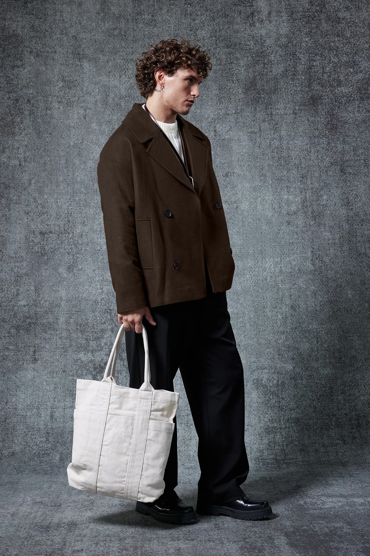 Dark brown double-breasted coat with structured shoulders and flap pockets.