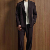 Men's dark brown oversized suit jacket and matching trousers with white ribbed shirt