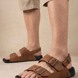 Brown suede slide sandals with two buckled straps, open toe, black outsole
