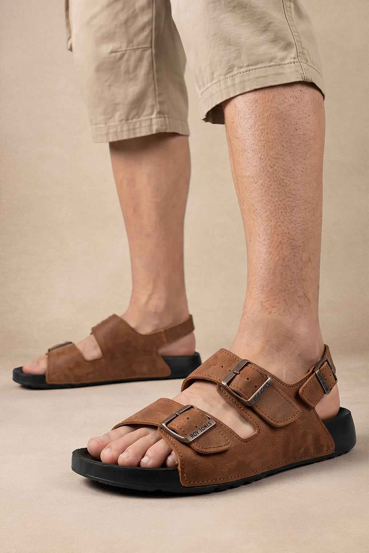 Brown suede slide sandals with two buckled straps, open toe, black outsole