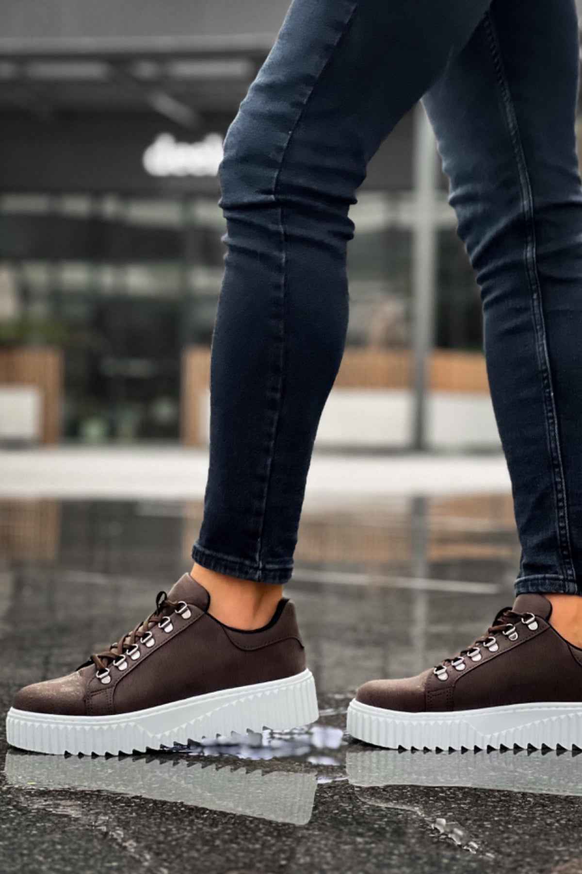 Men's brown sneakers with white treaded sole, lace-up eyelets, and stitching