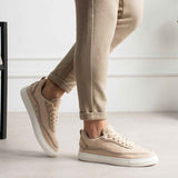 Men's beige canvas sneakers with white rubber sole, lace-up front, side stitching.
