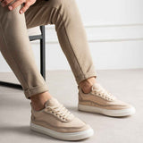 Men's beige canvas sneakers, front three-quarter view with lace-up vamp and white sole.