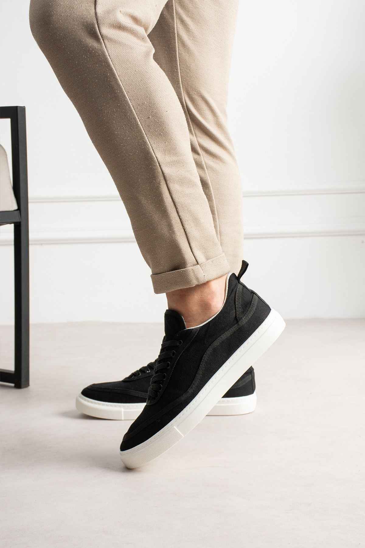 Men's black canvas sneakers with white rubber sole and lace-up design