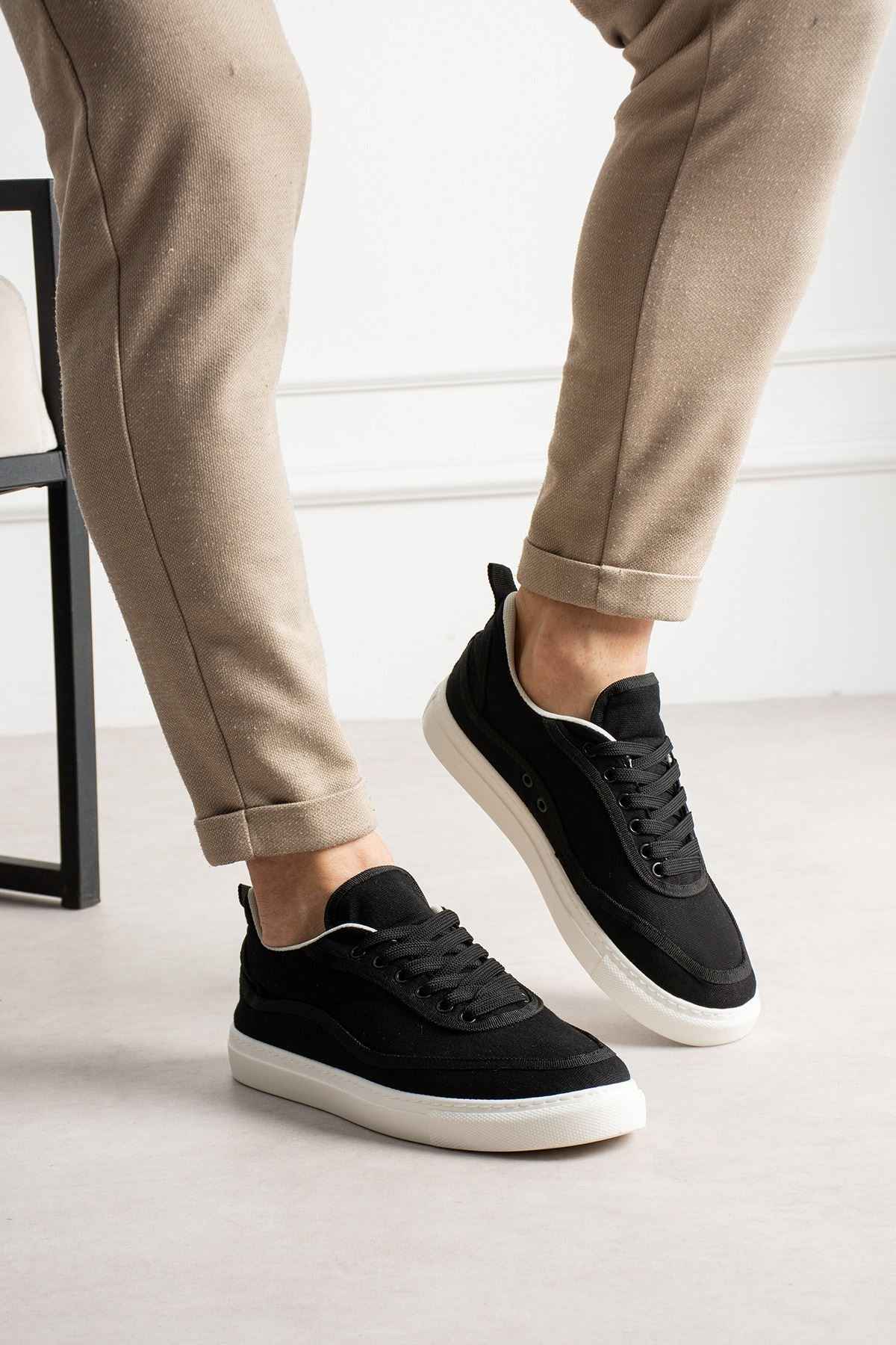 Men's black canvas sneakers with white sole, 3/4 front angle and lace-up