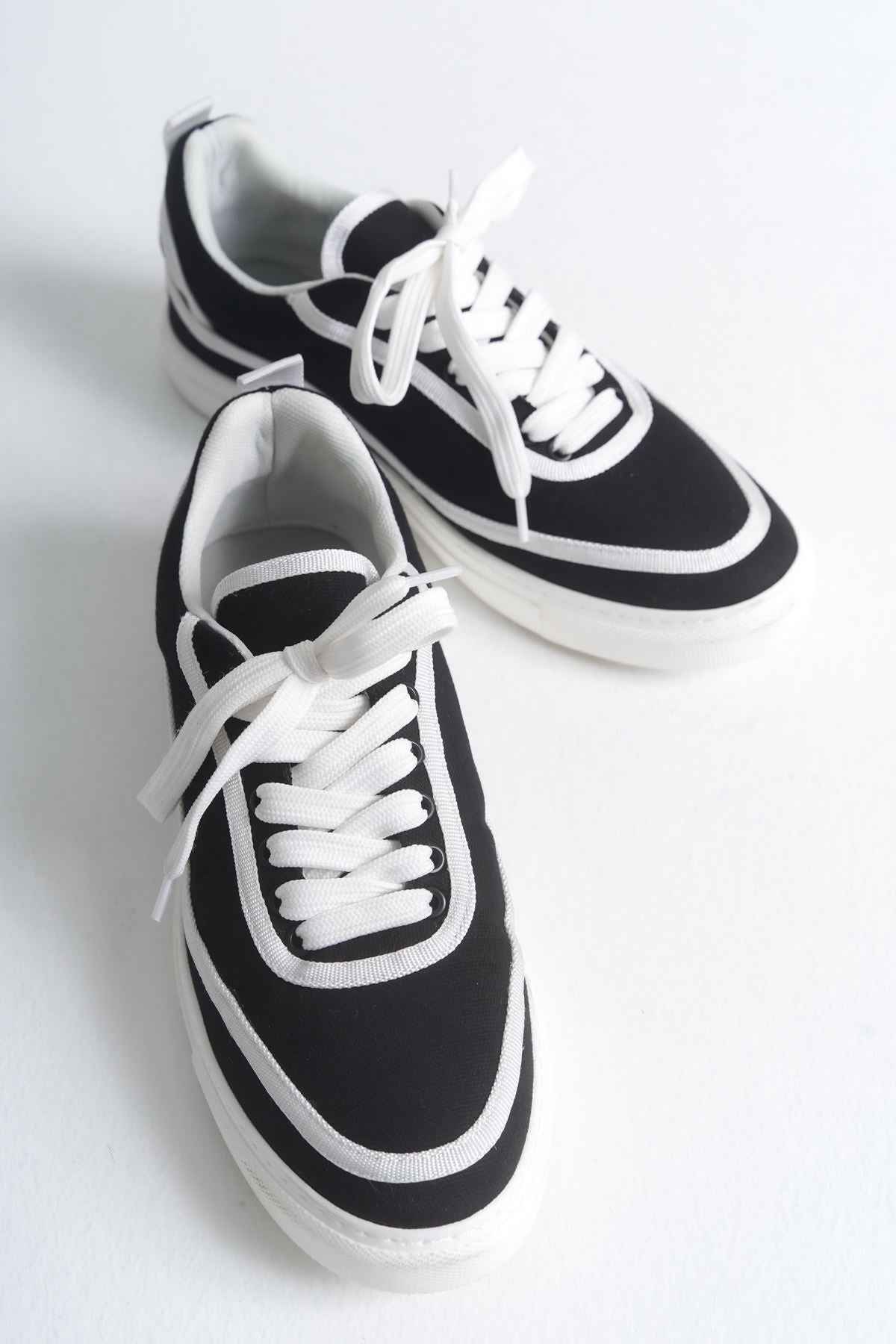 Pair of black canvas low-top sneakers with white laces and double side stripes