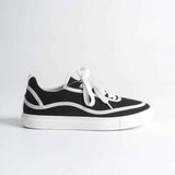 Black and white canvas low-top sneakers with white laces and bold side stripe