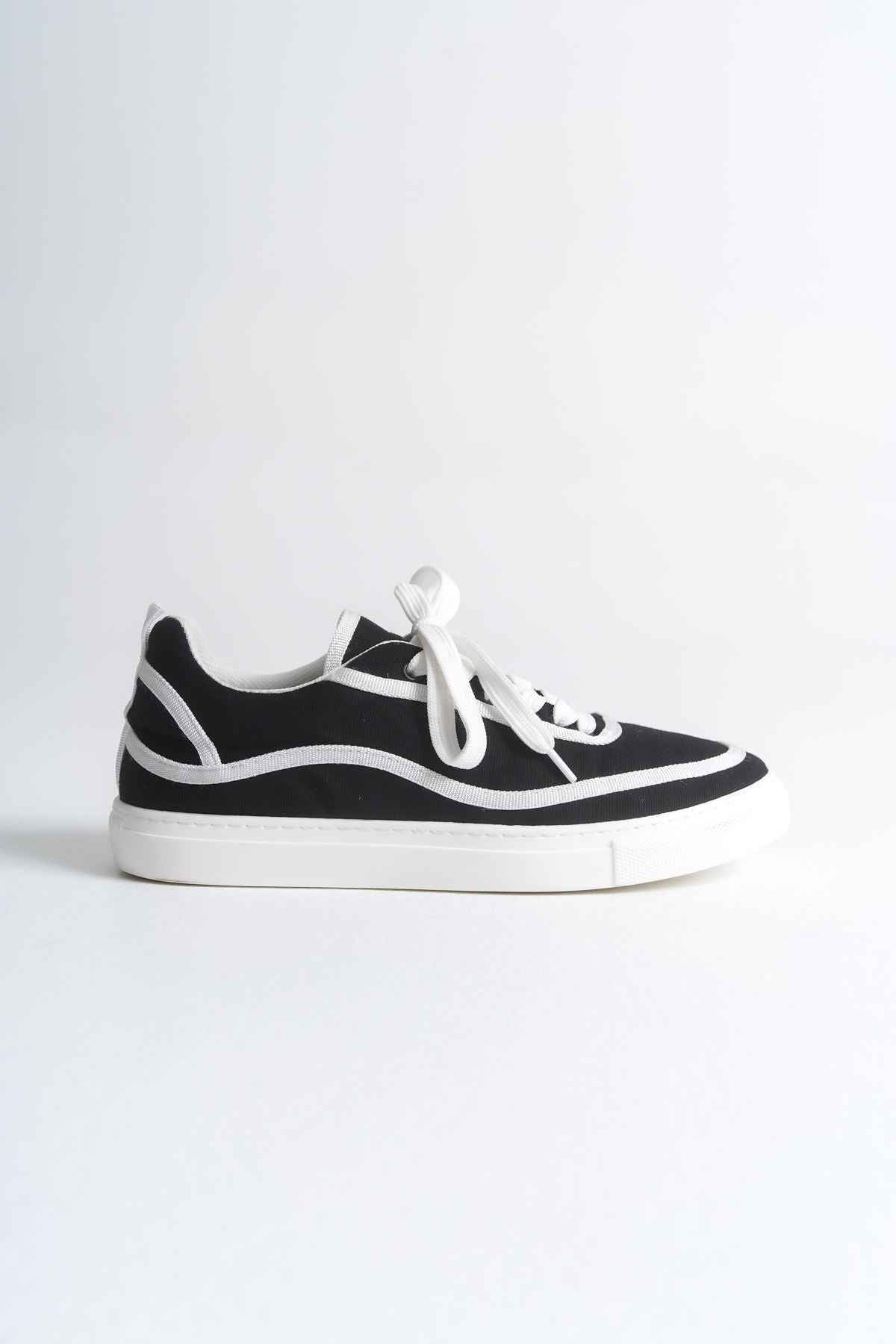 Black and white canvas low-top sneakers with white laces and bold side stripe