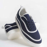 Dark blue canvas lace-up sneakers with white piping and thick white sole, side view
