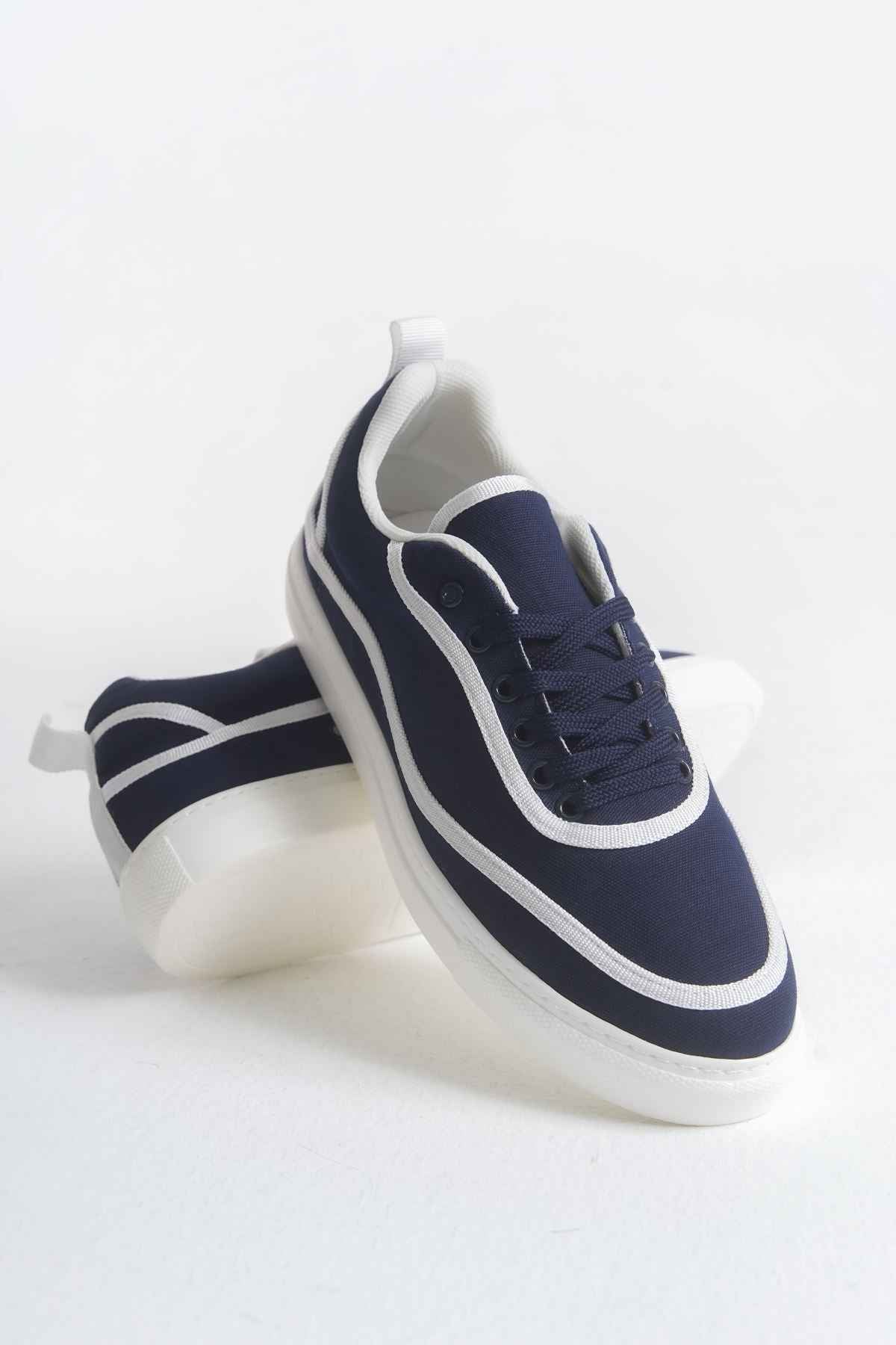 Dark blue canvas lace-up sneakers with white piping and thick white sole, side view