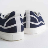 Dark blue canvas sneakers showing heel and toe with white stripes and white sole