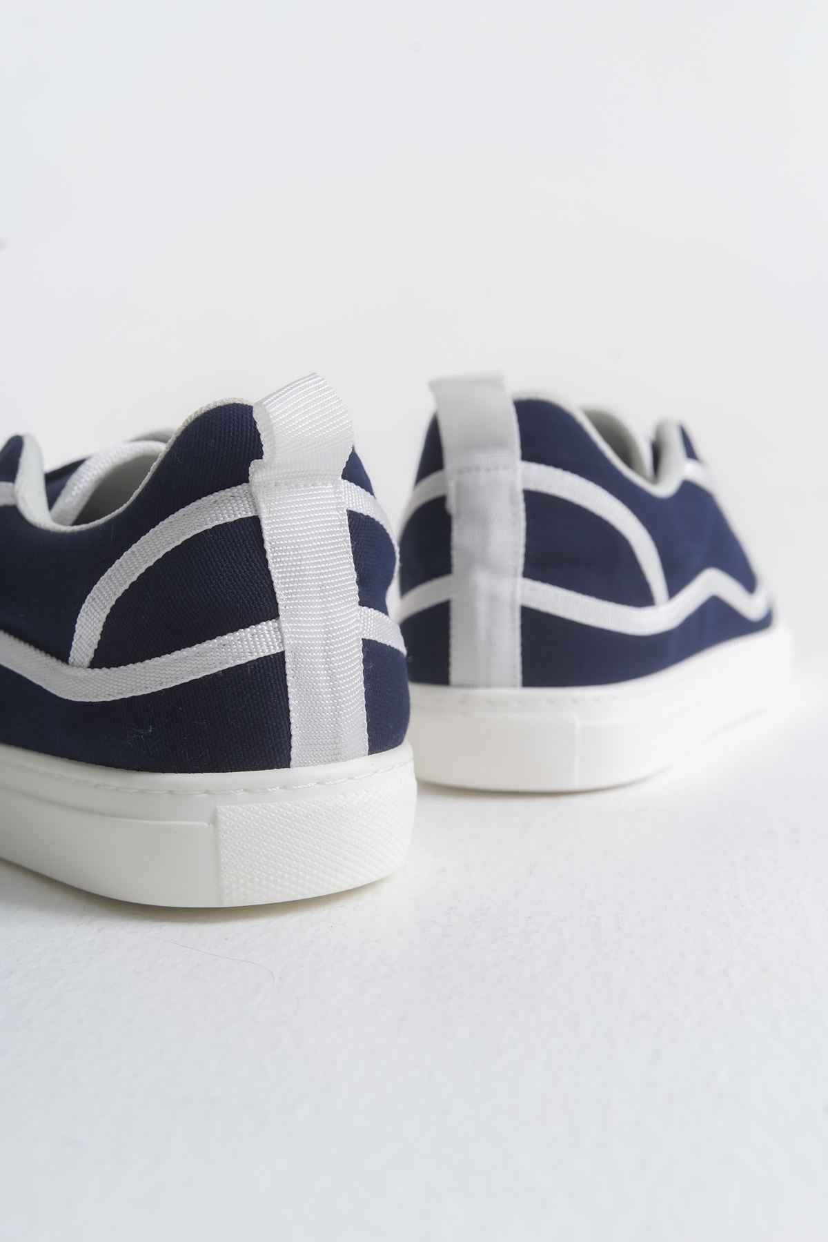 Dark blue canvas sneakers showing heel and toe with white stripes and white sole