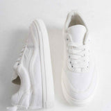 White canvas low-top sneakers with side profile and open heel