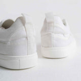 White canvas sneakers, rear view showing cushioned heel