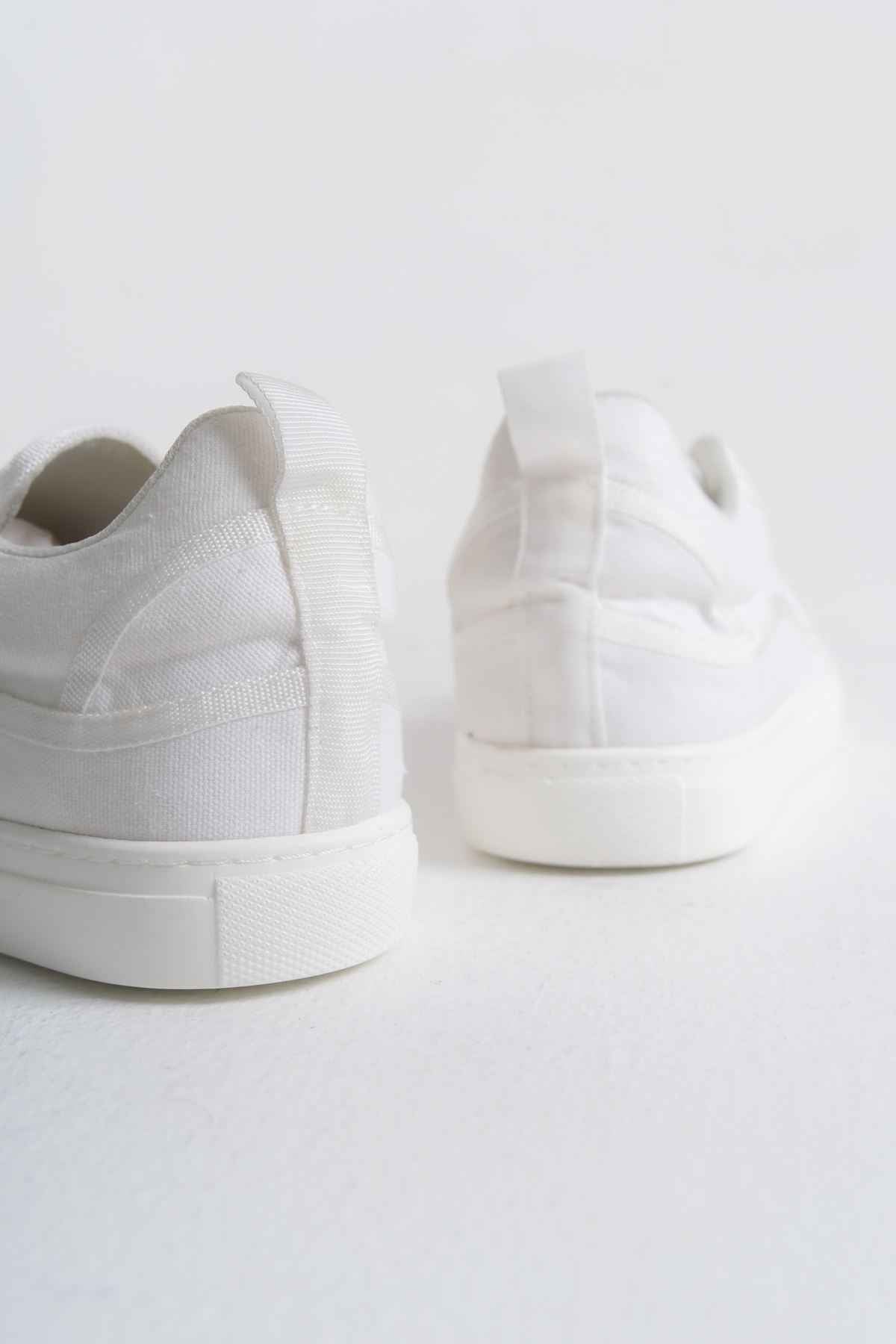 White canvas sneakers, rear view showing cushioned heel