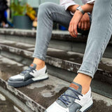 Casual sneakers in white and dark gray, lace-up front with orange heel label