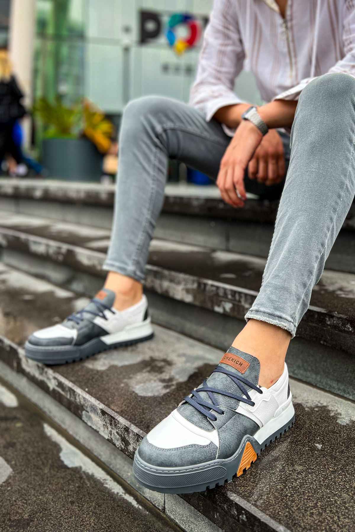 Casual sneakers in white and dark gray, lace-up front with orange heel label