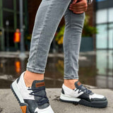 Casual sneakers in white and dark gray with lace-up front and orange heel patch