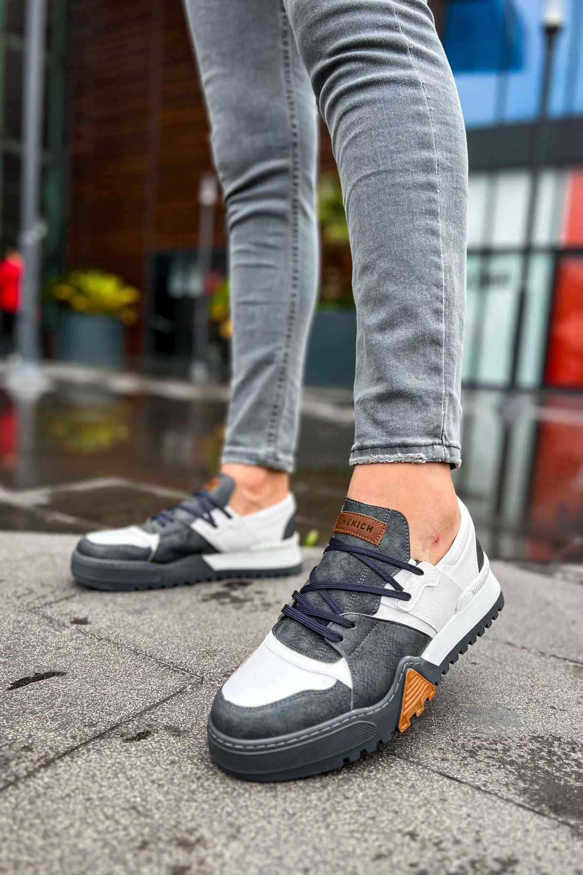 Casual sneakers with white toe, dark gray upper, lace-up design and orange heel patch