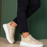 Beige casual sneakers on feet, side profile with double straps and white sole