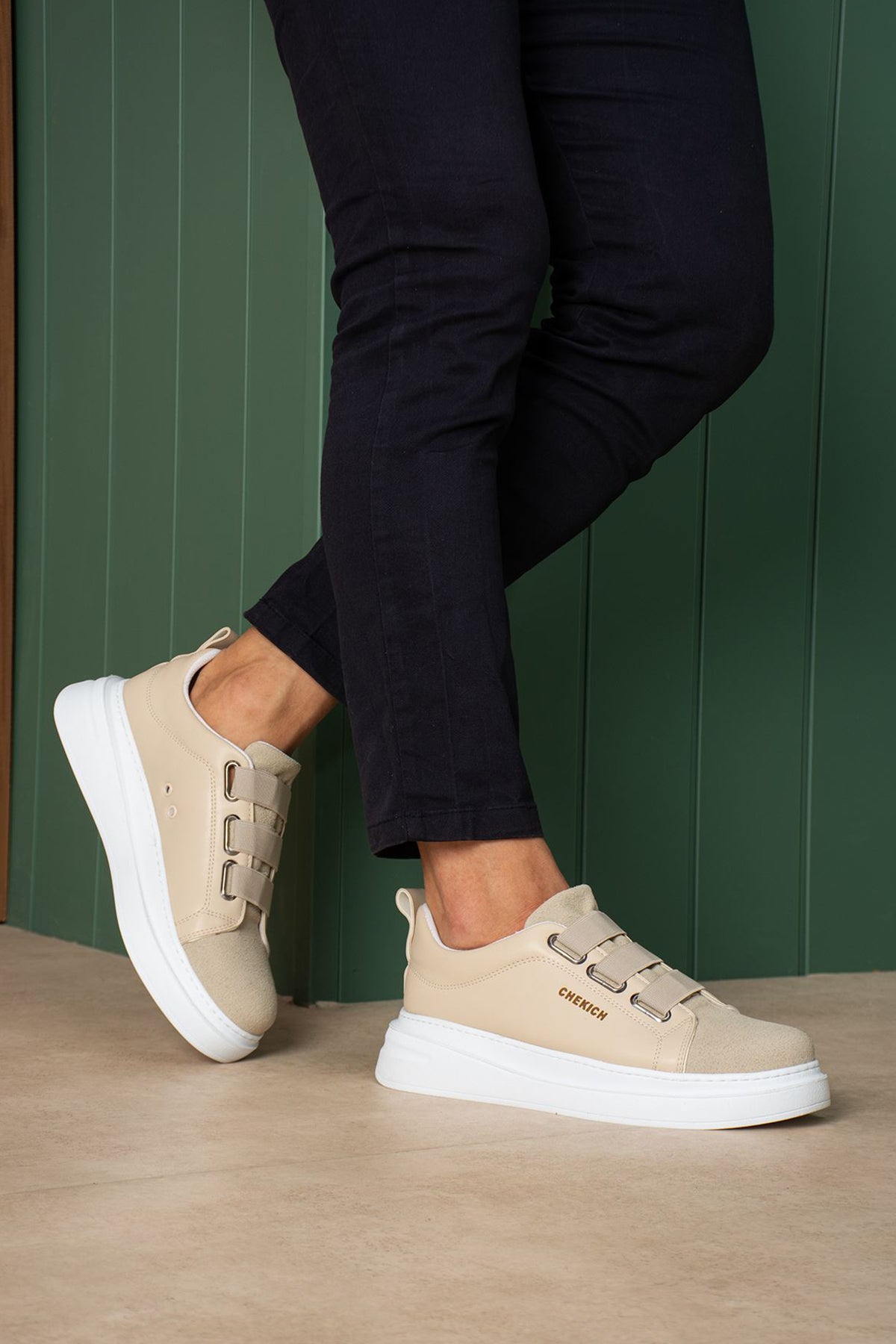 Beige casual sneakers on feet, side profile with double straps and white sole
