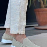 Light beige suede loafers, side view, with V-shaped seam and low white rubber sole