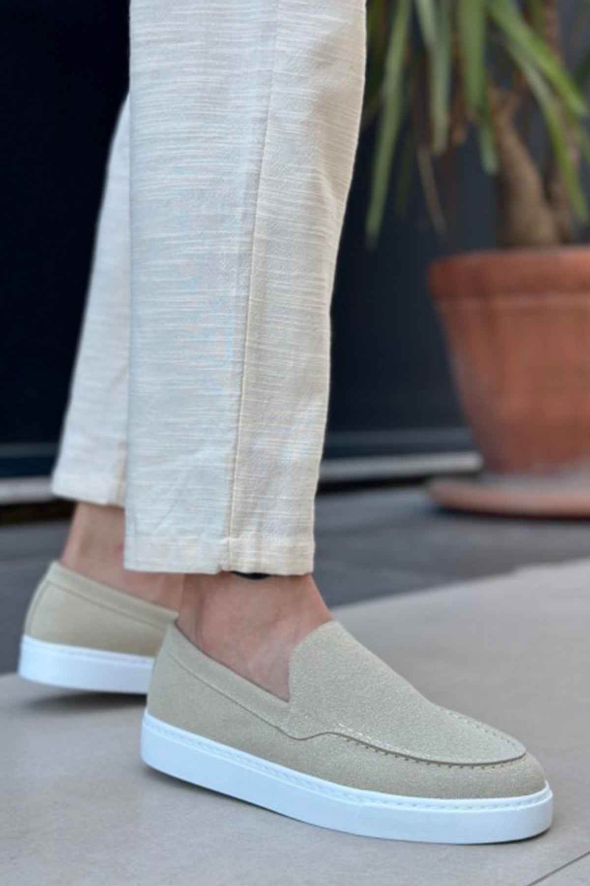 Light beige suede loafers, side view, with V-shaped seam and low white rubber sole