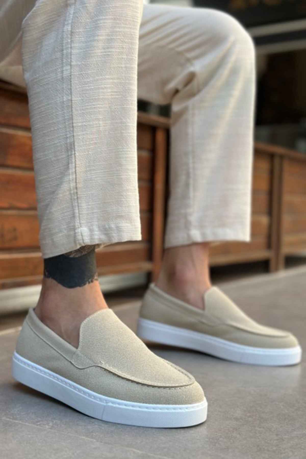 Light beige suede loafers, angled view, with V-shaped seam and low white sole