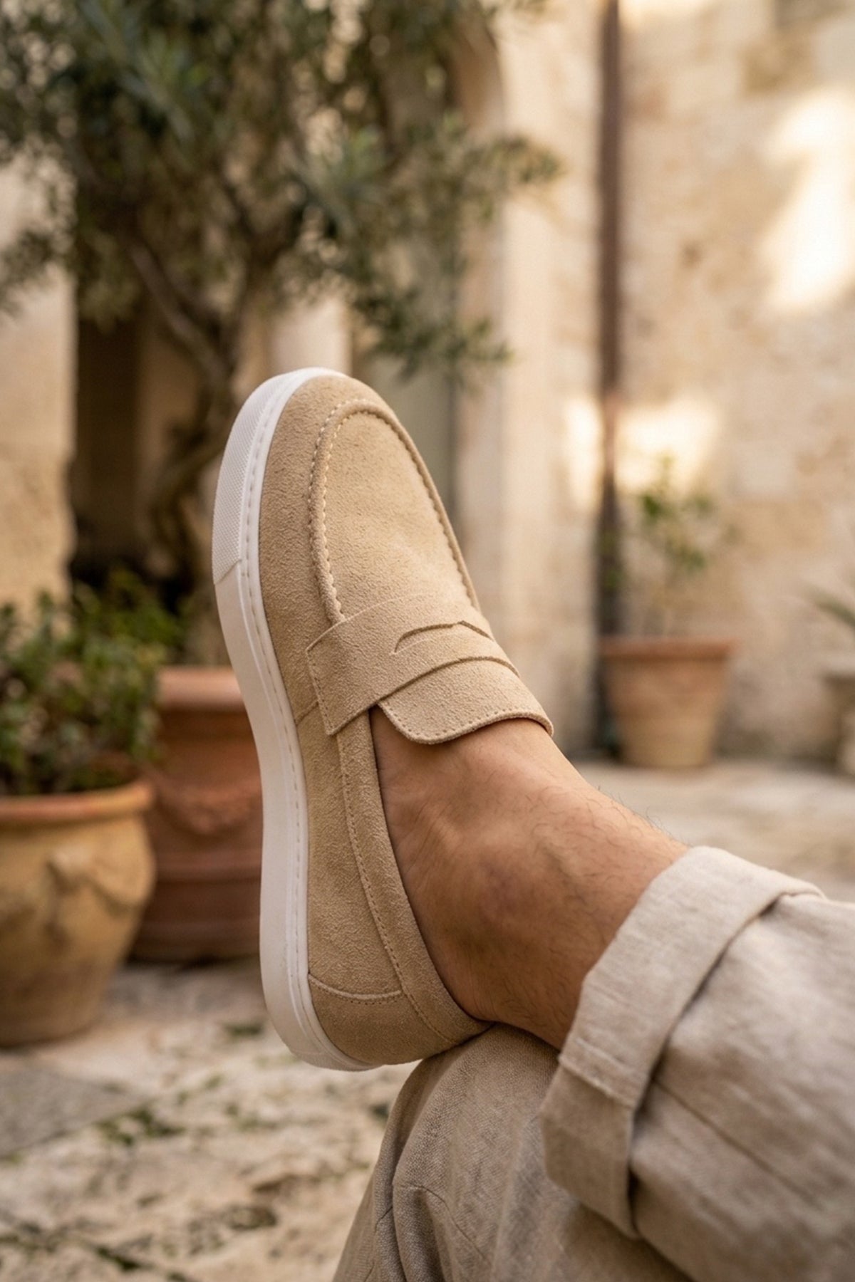 Men's beige suede loafer, close side view with stitched upper
