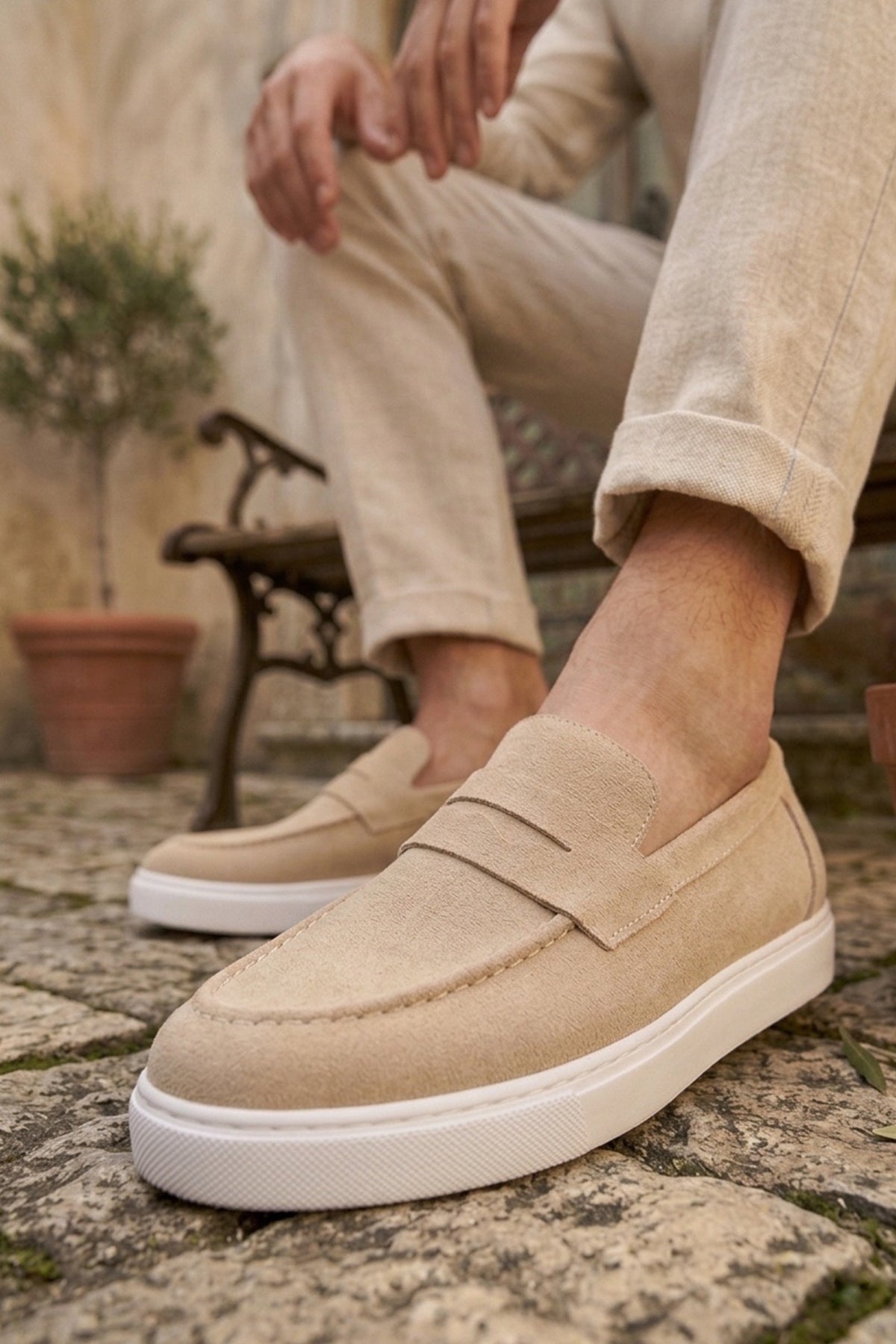 Men's beige suede loafer, front quarter view with saddle strap and white sole