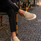 Beige suede loafers, low profile slip-on with white sole and side panel.