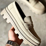 Men's beige suede loafer with strap vamp and contrast stitching, held in hand