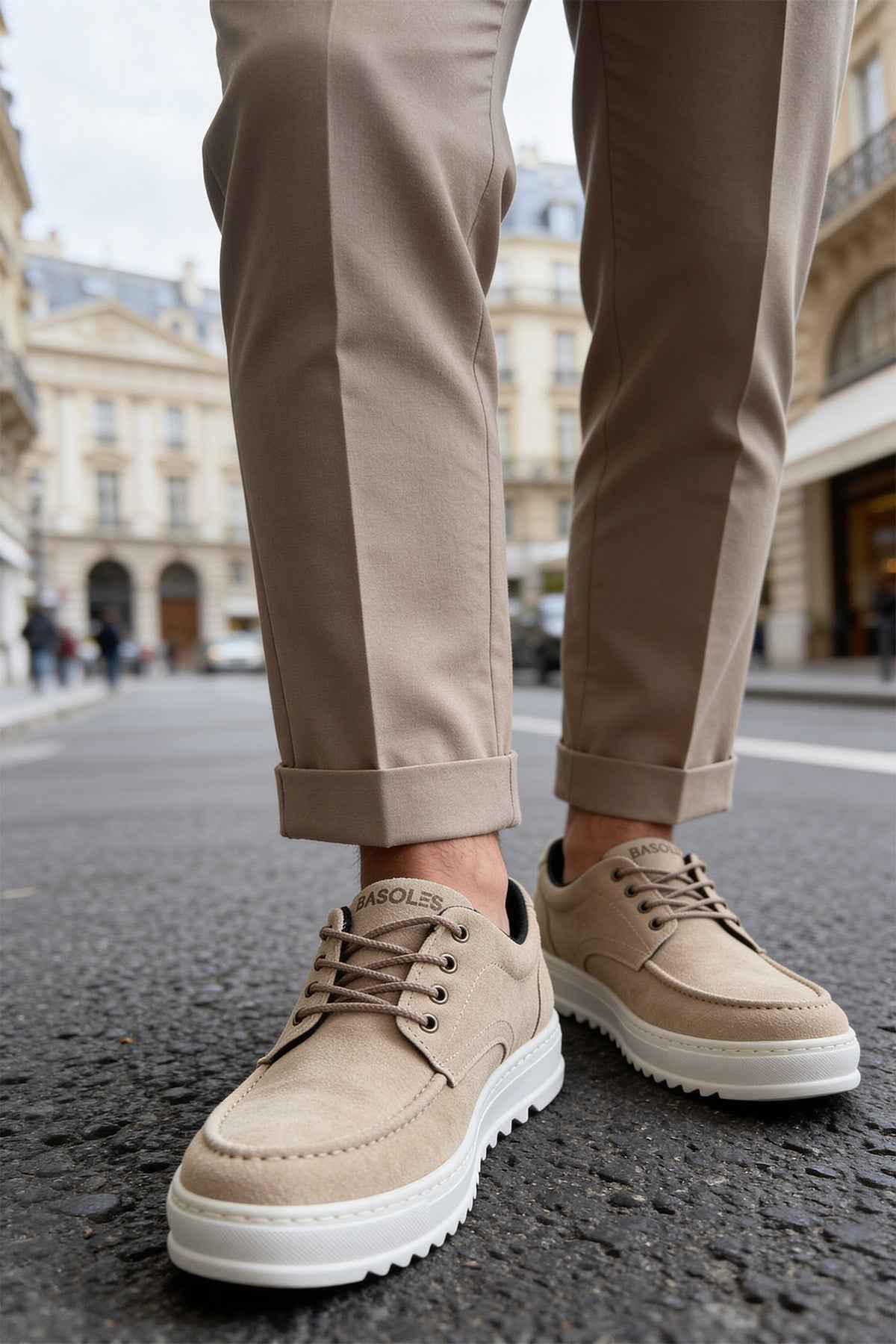 Beige suede lace-up sneakers with thick white sole, on feet